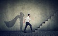 Super hero business man stepping up on stairs climbing to success Royalty Free Stock Photo