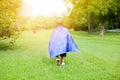 Super hero child walking towards the sunshine in the green park Royalty Free Stock Photo
