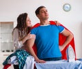 Super hero man husband ironing at home helping his wife Royalty Free Stock Photo