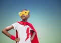 Super kid in red cape and yellow mask standing with hand on hip Royalty Free Stock Photo