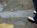 Super large colored rocks set in floor offset by gold toed flats with an attitude Royalty Free Stock Photo