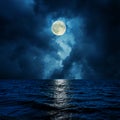 Super moon in clouds over water Royalty Free Stock Photo