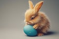 A super realistic image of an Easter bunny rabbit, with exquisitely detailed fur, gently cradling a matte blue painted egg