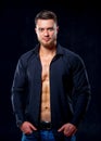 Super sexy man with tan abs and chest. Athletic man with unbuttoned dark shirt on gray background. Studio portrait Royalty Free Stock Photo