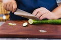 Super sharp Japanese kitchen knife cut zucchini into ultra thin slice on wooden chopping board