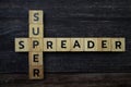 Super Spreader word letter on wooden background