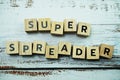 Super Spreader word letter on wooden background