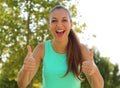 Super woman! Portrait of winner girl showing thumbs up. Positive smiling fitness healthy woman outdoor Royalty Free Stock Photo
