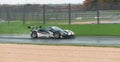 Supercar Ferrari GT 488 racing on wet raining asphalt track circuit spraying water