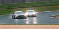 Supercar Mercedes anc Porsche racing on wet raining asphalt track circuit spraying water