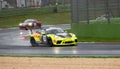 Supercar Porsche racing on wet raining asphalt track circuit spraying water