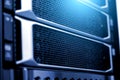 Server rack close up meshed hard drive cover blurred frame depth of field fluorescent blue light Royalty Free Stock Photo