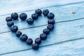 Superfood berries: blueberry heart on a wooden background