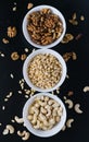 superfood concept, cedar, walnuts, cashew nuts in a plate on a black background Royalty Free Stock Photo