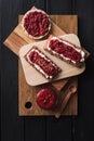 Superfood dessert. Chia seed raspberry jam with flax seeds and ricotta on wholegrain crispbread on black background top view