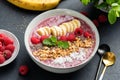 Superfood smoothie bowl with raspberry, banana, chia seeds, coconut and granola