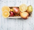 Superfoods and health or detox diet food concept variety of fruits in a wooden box kumquat, oranges, pear, lemon, top view