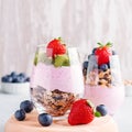 Superfoods layered pudding with granola, blueberry and strawberry in glasses. Yogurt with chia seeds, berries, kiwi and muesli for