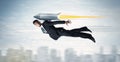 Superhero business man flying with jet pack rocket above the cit Royalty Free Stock Photo