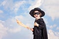 Superhero child with sward and costume on a blue sky background