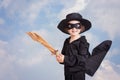 Superhero child with sward and costume on a blue sky background