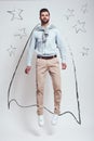 Superhero. Full length of confident bearded man wearing a drawn cape and jumping in studio against grey background with