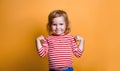 Superhero kid against yellow background. Girl power concept. Little kid girl in striped shirt Royalty Free Stock Photo