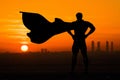 Superhero silhouette back view over watch the city at sunset or sunrise Royalty Free Stock Photo