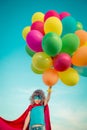 Superhero with toy balloons in spring field Royalty Free Stock Photo