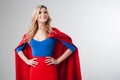 Superhero Woman. Young and beautiful blonde in image of superheroine in red Cape growing