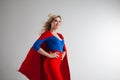 Superhero Woman. Young and beautiful blonde in image of superheroine in red Cape growing