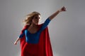 Superhero Woman. Young and beautiful blonde in image of superheroine in red Cape growing