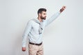 Superhero. Young bearded man is raising his hand up while standing against grey background. Enthusiasm concept.