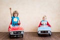 Superheroes children driving toy cars at home
