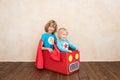 Superheroes children playing in cardboard box