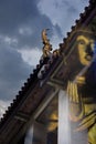 Superimposed of double exposures of Golden Buddha statue with a roof of Wat Pathum Wanaram, Bangkok.