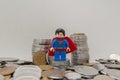 Superman on a pile of silver coins on white background