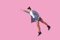 Superman. Portrait of cheerful ambitious brunette teenage girl flying with one raised hand, feeling super power. pink background