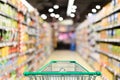 Supermarket aisle with empty green shopping cart Royalty Free Stock Photo