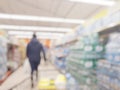 Blurred abstact background of shopping cart in supermarket . Blurry view inside department store with shopping trolley. Royalty Free Stock Photo