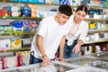 in supermarket couple choose nosh near showcase-refrigerator