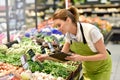 Supermarket employee in vegetable section Royalty Free Stock Photo