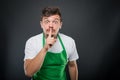 Supermarket employer posing showing silence gesture