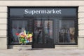 Supermarket exterior with shopping cart full of food