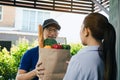 Supermarket food delivery staff deliver bags to female customers in front of the house