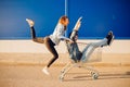 Supermarket, happy young woman carrying man in cart store for shopping, hands raised up. Couple family sunset Royalty Free Stock Photo