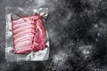 Supermarket packaged raw lamb rib rack, on black dark stone table background, top view flat lay, with copy space for text Royalty Free Stock Photo