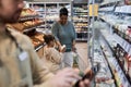 Supermarket setting black woman shopping for groceries with little girl Royalty Free Stock Photo