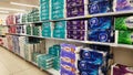 Supermarket shelves with various brands of toilet papers