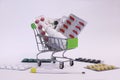 A supermarket trolley full of blister pills, a lot of pills in a wheelbarrow.